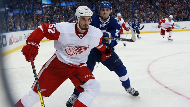 Red Wings defenseman Jonathan Ericsson (52) and Lightning left wing Jonathan Drouin (27) fight to control the puck during the third period of the Wings' 5-2 loss in Game 2 of the Eastern Conference quarterfinals Friday in Tampa.