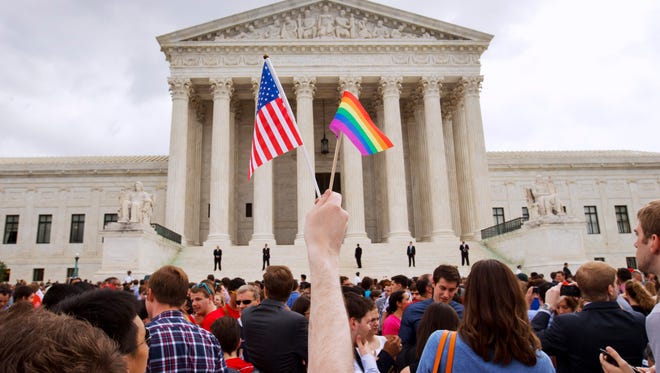 FILE - In this June 26, 2015 file photo, the crowd celebrates outside of the Supreme Court in Washington after the court declared that same-sex couples have a right to marry anywhere in the U.S. A brief exchange during Supreme Court arguments in the same-sex marriage case has exploded into a full-blown crisis for some conservatives who warn that the IRS could start revoking the tax-exempt status of religious groups that oppose gay marriage. The attorneys general of 15 states have written Congress asking for legislation to protect religious schools and other groups. Bills in the House and Senate are gaining support.(AP Photo/Jacquelyn Martin, File)