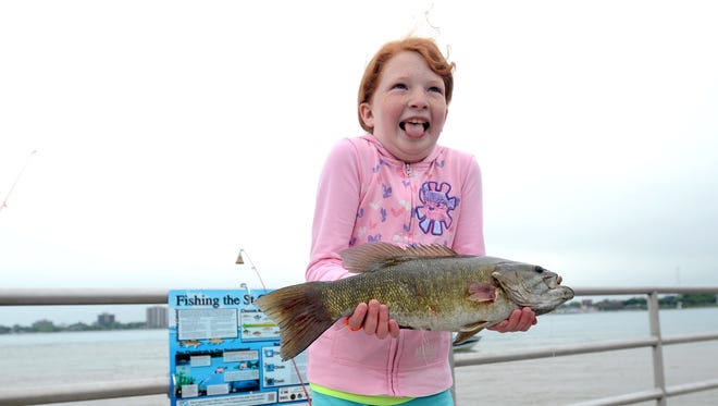 Emily Johnson, of Richmond, holds a smallmouth bass during the Summer Free Fishing Weekend.