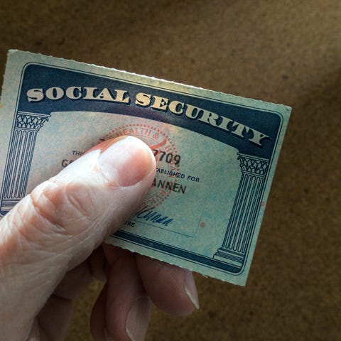 A hand holding a Social Security card