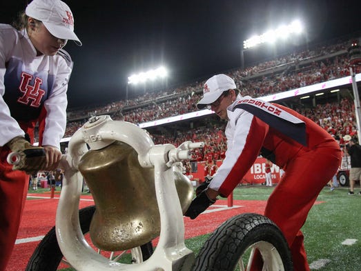 Members of the Houston Cougars band ring the bell after