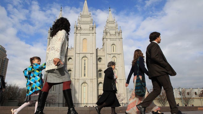 In this April 5, 2014 file photo, people walk past the Salt Lake Temple in Salt Lake City. On Tuesday, Jan. 27, 2015, Mormon leaders made a national appeal for what they called a "balanced approach" in the clash between gay rights and religious freedom, promising to support some housing and job protections for gays if they back some exemptions for religious objectors to same-sex marriage.