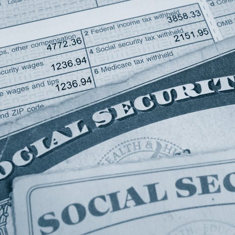 Two Social Security cards lying atop a W2 tax form