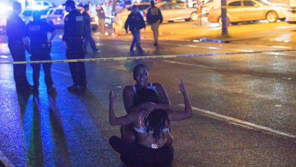 People react at the scene of a shooting in New...
