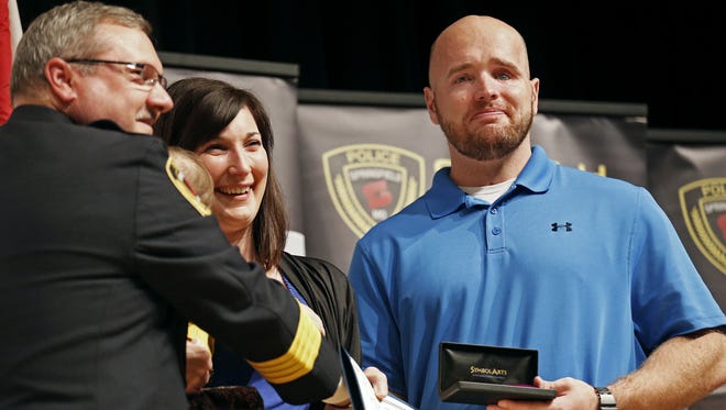 Retired Springfield police officer Aaron Pearson (with his wife, Amanda) receives a Purple Heart from Police Chief Paul Williams in 2015.