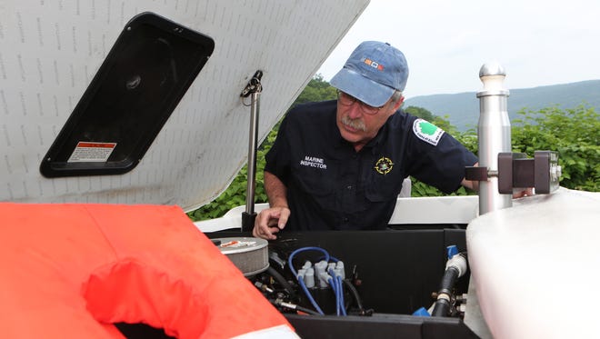 Marine Inspector Peter Gionet with the NYS Department of Parks and Recreation inspects David Kovacik's boat June 16, 2016 at the Charles Point Marina in Peekskill. Kovacik is with the NYC Water Ski and Wakeboard School. 