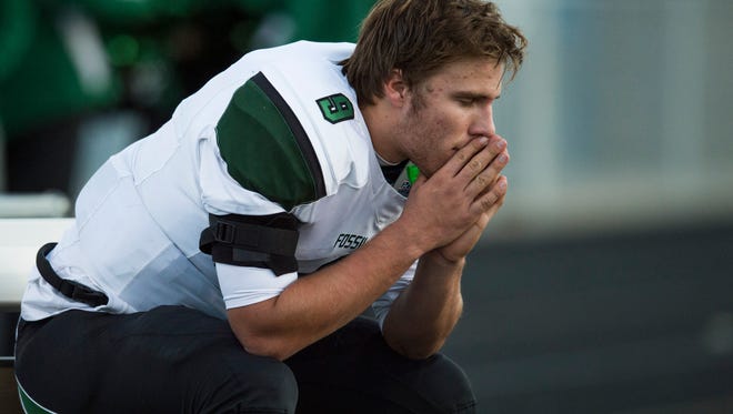 Fossil Ridge High School quarterback Griffin Roberts sits on the bench during defensive play in a playoff football game against Ralston Valley at the North Area Athletic Complex in Arvada, Co. Thursday, November 5, 2015. 