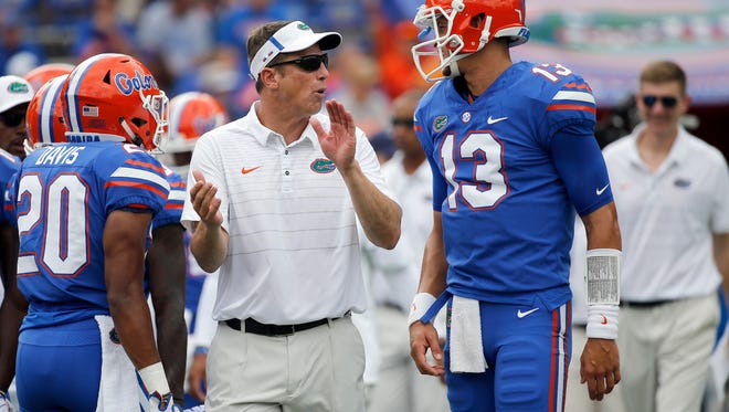 Sep 16, 2017; Gainesville, FL, USA; Florida Gators offensive coordinator Doug Nussmeier talks with quarterback Feleipe Franks (13) before a game against the Tennessee Volunteers at Ben Hill Griffin Stadium. Mandatory Credit: Kim Klement-USA TODAY Sports
