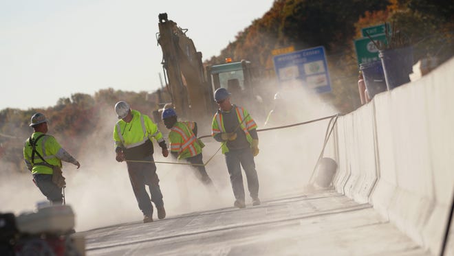 Concrete workers grind the deck of I-95 south of the Route 1 overpass.