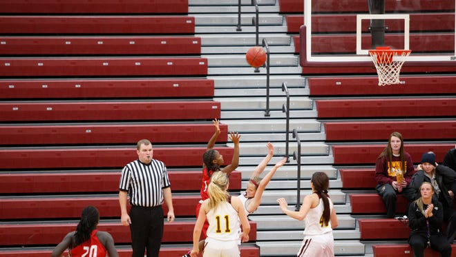 East's Eriana Brown banks in the game-winning basket over Ankeny defender Molly Close at the buzzer to give the Scarlets a 49-48 victory on Friday at Ankeny.