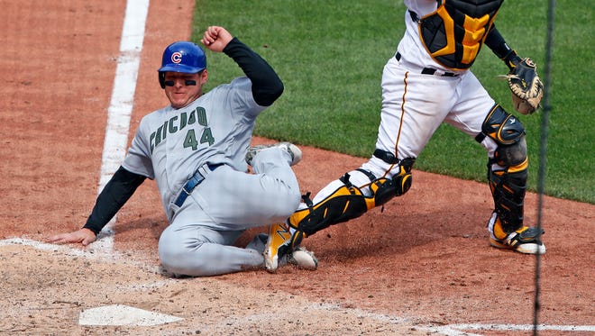 The Cubs' Anthony Rizzo slides into the back foot of Pirates catcher Elias Diaz in the eighth inning of Monday's game. The contact led to an errant throw by Diaz that allowed two additional runs to score.