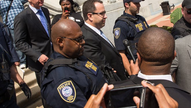 Jared Fogle (C) walks out of the courthouse on August 19, 2015 in Indianapolis, Indiana.  Fogle is expected to plead guilty to federal charges relating to child pornography and having sex with minors.