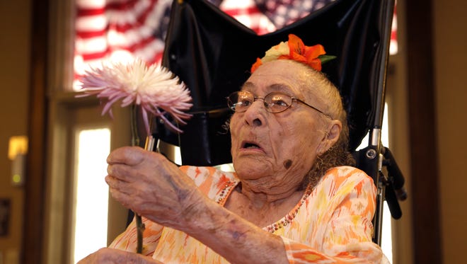 Gertrude Weaver holds a flower given to her a day before her 116th birthday, at Silver Oaks Health and Rehabilitation Center in Camden, Ark., Thursday, July 3, 2014.  The Gerontology Research Group says Weaver is the oldest person in the United States and second-oldest person in the world. (AP Photo/Danny Johnston)