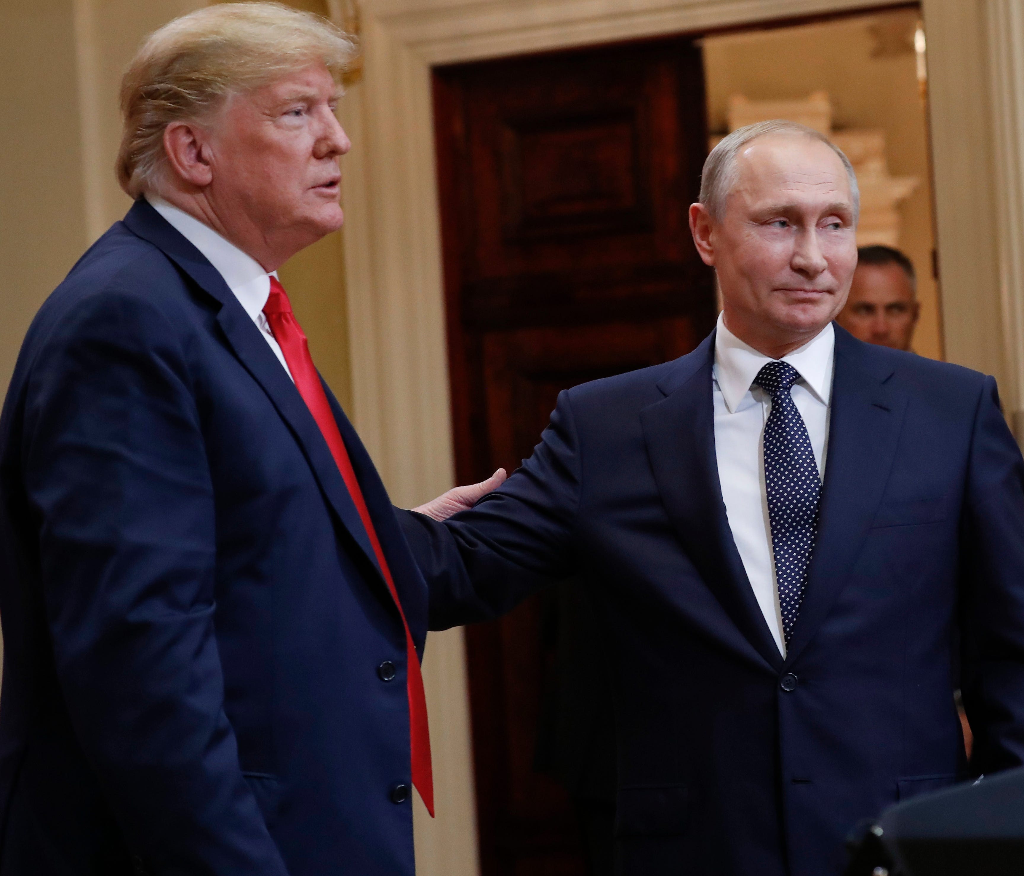 President Donald Trump (left) and Russian President Vladimir Putin (right) leave the stage together at the conclusion of their joint news conference at the Presidential Palace in Helsinki, Finland.