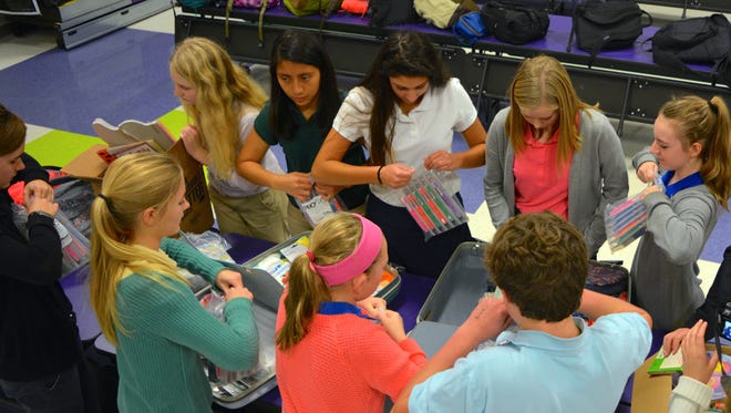 Students in the Southern Delaware School of the Arts' National Junior Honor Society pack suitcases with everyday items for guests of the HALO shelter in Salisbury.