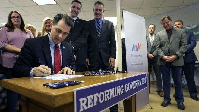 Governor Scott Walker signs Assembly Bill 373 Friday, Feb. 12, 2016, at Manpower Group in Appleton.
