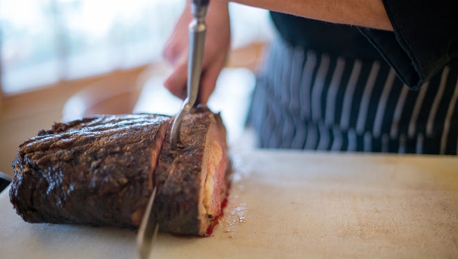 A Red Osier chef carves a slice of its signature prime rib tableside.