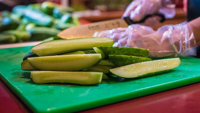 Mykel Brawley, owner of the Fort Collins Pickle Company, slices freshly scrubbed cucumbers as she begins the pickling process in her home kitchen on Thursday, August 10, 2017.