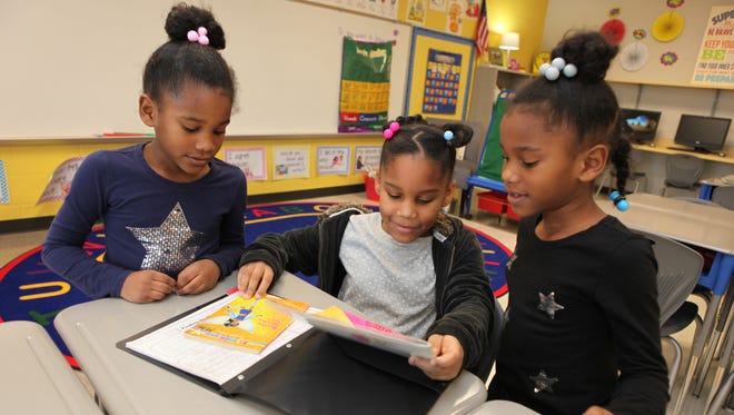 London Smith, a second-grader at John Colemon Elementary in Smyrna, shows her sisters Jordyn, left, and Jazzlyn, also students at the school, her new desk and some of her work during an open house at the school earlier this year.