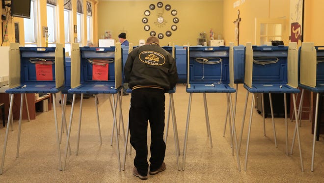 A voter fills out his ballot at St. Joseph’s Parochial School in Green Bay.