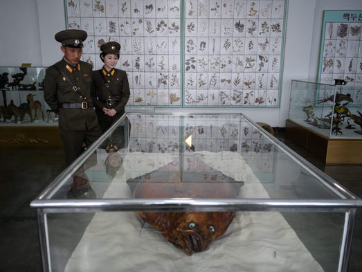 Staff members stand before preserved 'flat-fish' in