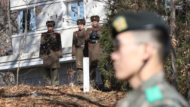 In this Nov. 27, 2017, file photo, North Korean soldiers look at the South side as a South Korean stands guard near the spot where a North Korean soldier crossed the border on Nov. 13 at the Panmunjom, in the Demilitarized Zone, South Korea.