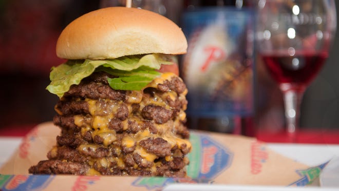 The "Wayback Triple Triple", a cheeseburger with nine burger patties, is displayed during the What's New This Season at Citizens Bank Park event held Tuesday at Citizens Bank Park in Philadelphia. 03.31.15