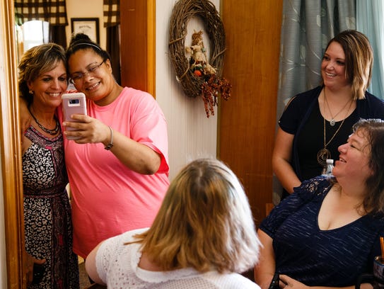 Oak Place staff member Deb King, left, takes a photo