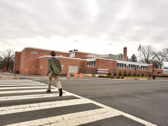 A student crosses the street at Nutley Senior High School, closed for a day following an online threat.