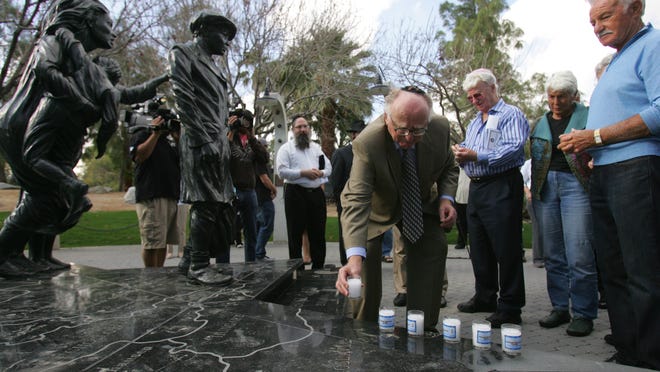 Steven Geiger places a candle at the Desert Holocaust Memorial during last year’s International Holocaust Remembrance Day Observance. This year’s ceremony marks the 70th anniversary.