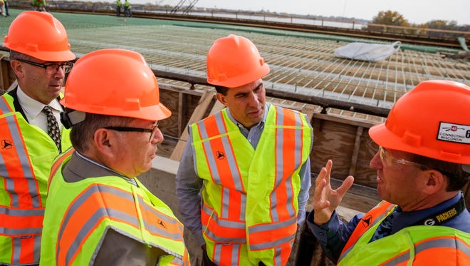 Gov. Scott Walker (center) speaks with Department of Transportation members Tom Rhatican (from left) Mark Gottlieb and Tom Buchholz while touring the Roland Kampo Bridge in the Town of Menasha Tuesday following a press conference about DOT projects.