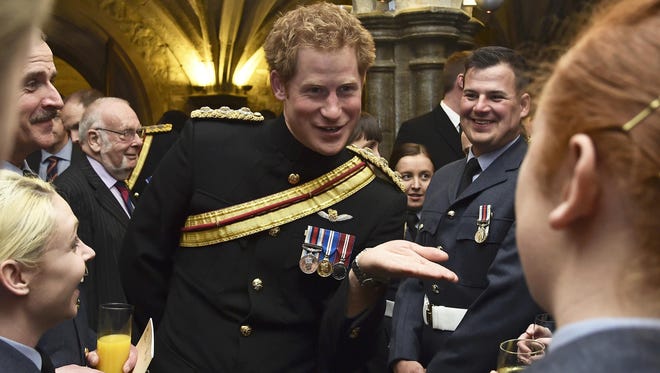 Prince Harry talked with armed forces personnel at reception following service to mark end of Britain's combat operations in Afghanistan at St. Paul Cathedral in London March 13.