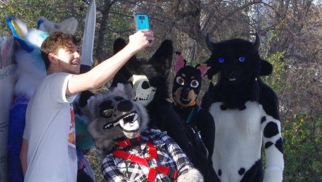 Cristian Alvitre of Anderson takes a selfie with a group of friends dressed as "Furries" Sunday at the Sundial Bridge in Redding.