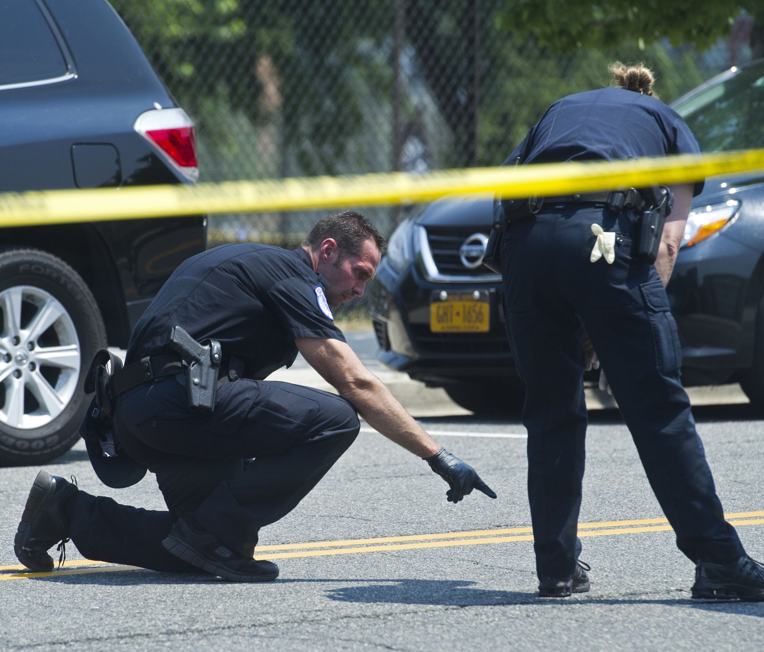 Crime scene investigators search for evidence at the scene of the shooting in Alexandria, Va., on June 14, 2017, where House Majority Whip Steve Scalise and others were shot during a congressional baseball practice.