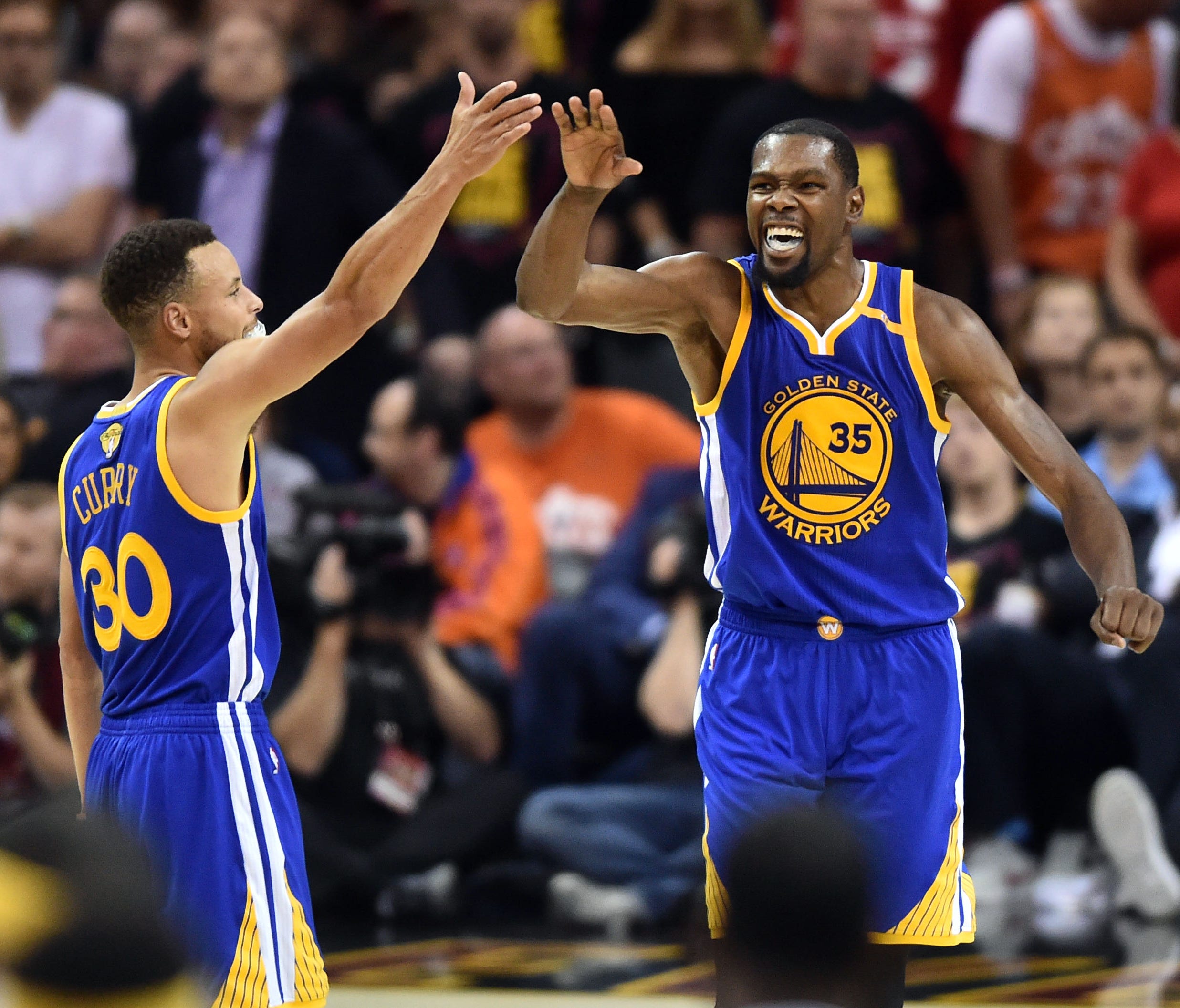 Golden State Warriors guard Stephen Curry (30) and forward Kevin Durant (35) celebrate during the fourth quarter against the Cleveland Cavaliers in game three of the 2017 NBA Finals at Quicken Loans Arena.