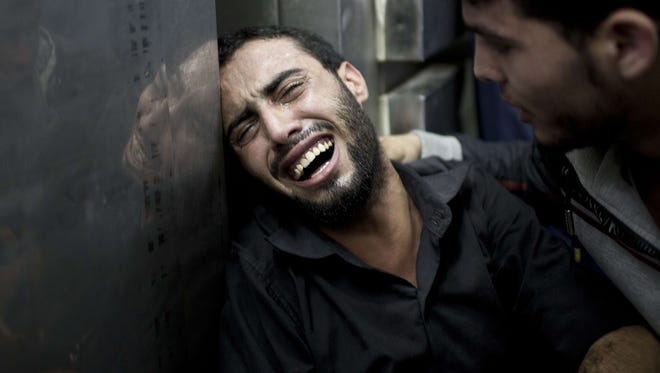 A Palestinian man grieves over the death of relatives at the morgue of the Kamal Adwan hospital in Beit Lahiya on Thursday.