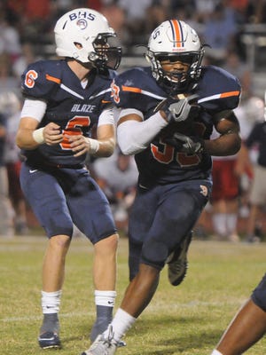 Blackman QB Conner Mitchell hands off to Master Teague for one of Teague's 48 carries in a 35-21 win over Cookeville.