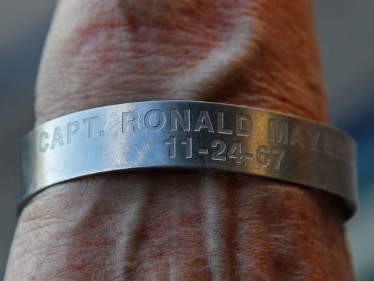 Jan Buttler, bottom righ, of Lake Como, wears bracelet