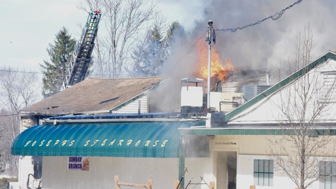 Fire erupts from the roof of Joseph's Steakhouse in Hyde Park Monday afternoon.