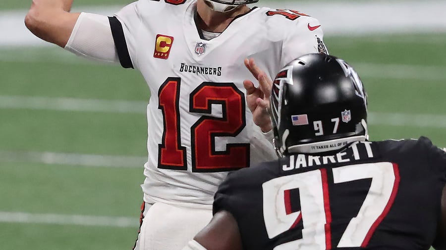Tampa Bay Buccaneers quarterback Tom Brady (12) completes a pass under pressure from Atlanta Falcons defensive tackle Grady Jarrett during the fourth quarter of an NFL football game Sunday, Dec. 20, 2020, in Atlanta. (Curtis Compton/Atlanta Journal-Constitution via AP)