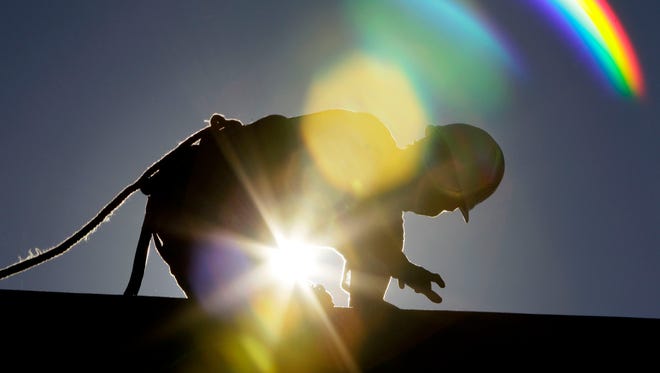 A construction worker toils on a roof in Chapel Hill, N.C., as temperatures inched into the 90s on July 6, 2010.