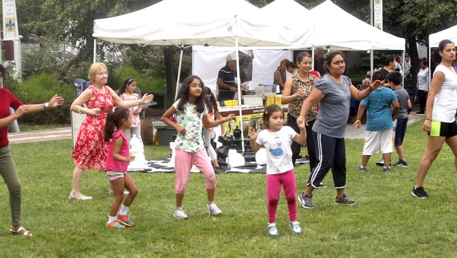 Adults and kids take part in a Zumba dance session during Dance En Plein Air, a weekly dance program at the park at the New Rochelle library July 9, 2016. The weekly program, sponsored by the New Rochelle Council on the Arts, takes place during the weekly farmer's market and features a different style of dance each week. 