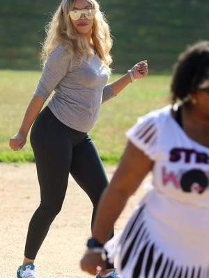 Deauna Froneberger dances along as Kat Scott, with the Purple Charlotte Steppers, instructs a group of dancers at the ballfield at Erwin Park on North Pryor Street on Saturday morning, Nov. 7, 2020, during Big Sister Team Building's Jerusalema Dance Challenge.