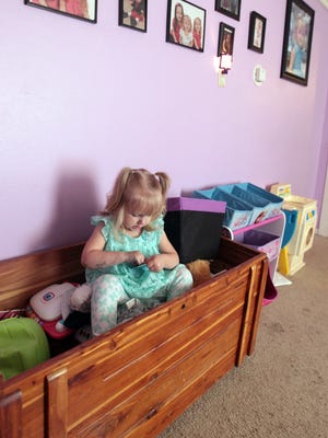 Two-year-old Kadileyah, who has   hepatitis C, sits in a toy box and plays in the home of her paternal grandmother, Angelia Crouch of Hamilton, who has legal custody of the child.