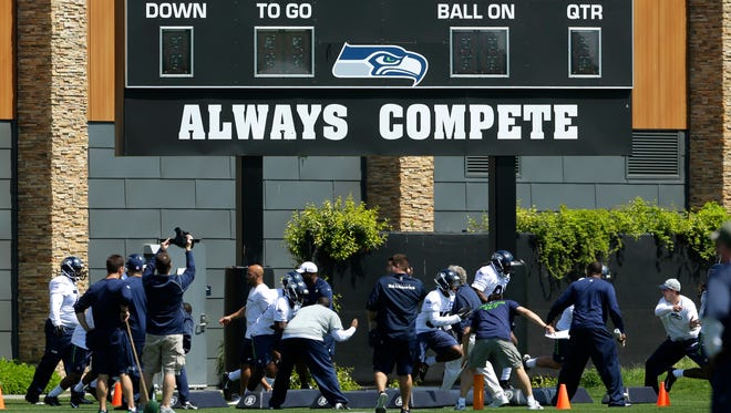 Seattle Seahawks rookie players run a drill under the scoreboard at the team's practice facility in Renton, Wash., during NFL football rookie minicamp, Friday, May 8, 2015, in Renton, Wash.