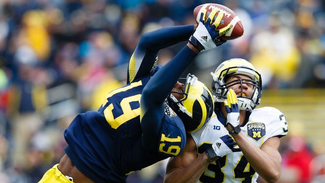 Michigan Wolverines tight end Devin Funchess (19) makes a catch over defensive back Jeremy Clark (34) during the Spring Game at Michigan Stadium.
