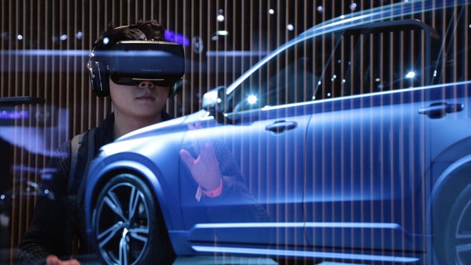 Hyundai Motors worker Kim Hyung Jun gets a look at the interior of the all-new Volvo XC90 through Oculus Rift, a virtual reality headset, during the 2015 North American International Auto Show at Cobo Center on Monday, Jan.12, 2015, in Detroit.