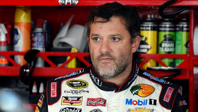 FILE - In this Sept. 13, 2014, file photo, NASCAR driver Tony Stewart (14) looks out from his garage during a practice for the NASCAR Sprint Cup Series auto race at Chicagoland Speedway in Joliet, Ill.