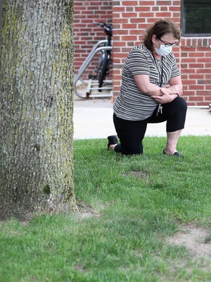 Chaplain Peggy O'Neil Files takes a knee for 8:46 during a moment of silence for George Floyd during their vigil outside the hospital on Thursday, June 11, 2020.