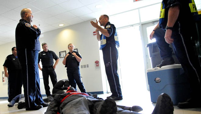 Members of the Sussex County Paramedics Joseph Pawelek, Tom Jefferson, Todd Hickman (Bethany Fire) and Stephanie Davis are briefed by Jeff Cox (right) Sussex County EMS captain and training officer, after their simulated Rescue Task Force training during which they "rescued" individuals and brought them to the designated "cold" area.